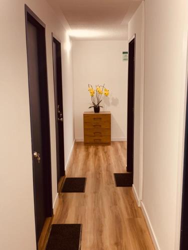 a hallway with two doors and a dresser with yellow flowers on it at CASA CREAZZO 62 - Movistar Arena in Bogotá