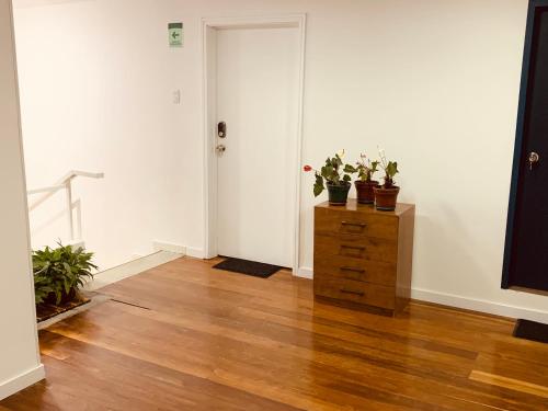 an empty room with a dresser with potted plants on it at CASA CREAZZO 62 - Movistar Arena in Bogotá