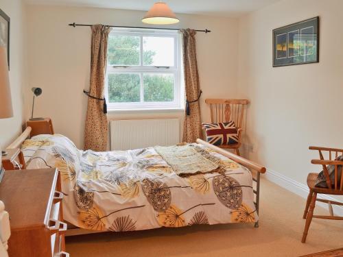 a bedroom with a bed and a window at Berts Cottage in Fordingbridge