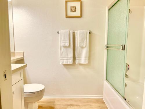a bathroom with a shower and a toilet and towels at Le Jardin - Remote Work Getaway in SoCal in Irvine