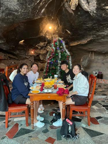 a group of people sitting around a table with a christmas tree at Tam Coc Horizon Bungalow in Ninh Binh