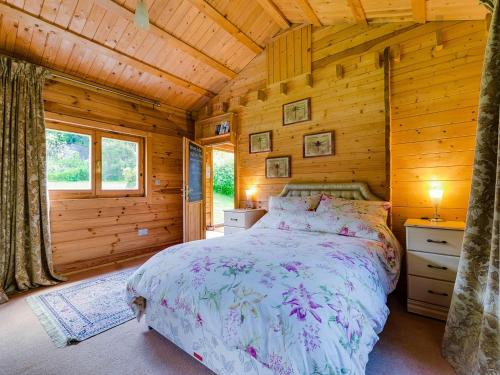 a bedroom with a bed in a log cabin at Ash Mill Cabin in Ashreigney