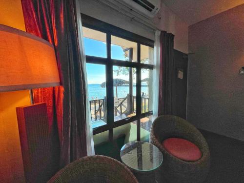 a room with a window with a view of the ocean at Tunamaya Beach & Spa Resort Tioman Island in Tioman Island