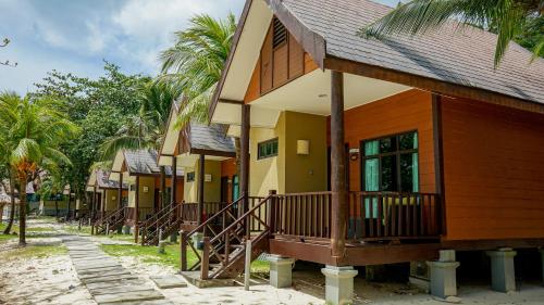 a row of houses on a street with palm trees at Tunamaya Beach & Spa Resort Tioman Island in Tioman Island