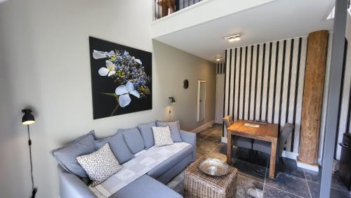a living room with a blue couch and a table at The Barnyard in Balinge