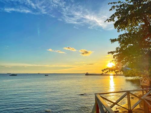 a sunset over a body of water with a pier at Tunamaya Beach & Spa Resort Tioman Island in Tioman Island