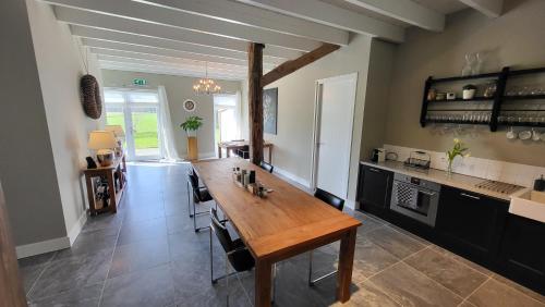 cocina con mesa de madera en una habitación en The Barnyard, en Balinge