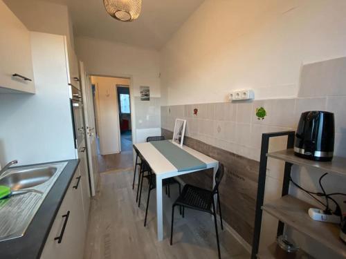eine kleine Küche mit einem Tisch und Stühlen in der Unterkunft Blue Chili 17 Schöne 3 Zi Toplage Boxspringbett Balkon Wifi in Magdeburg