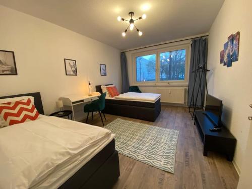 Schlafzimmer mit einem Bett, einem Schreibtisch und einem Fenster in der Unterkunft Blue Chili 17 Schöne 3 Zi Toplage Boxspringbett Balkon Wifi in Magdeburg