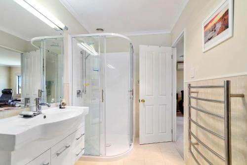 a bathroom with a shower and a sink at Paradise Hideaway in Rotorua