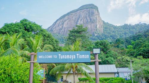 a sign in front of a mountain with trees at Tunamaya Beach & Spa Resort Tioman Island in Tioman Island