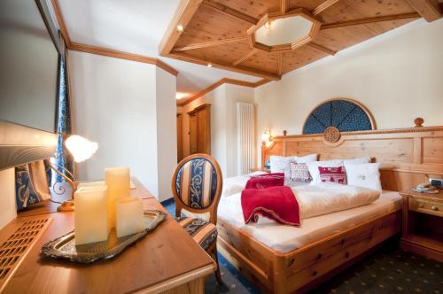 a bedroom with a bed and a desk in a room at Hotel Gianna in Madonna di Campiglio