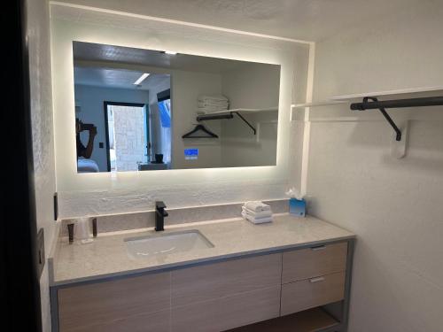 a bathroom with a sink and a large mirror at Sway Hotel in Lake Havasu City
