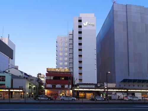 une ville avec des voitures garées devant un grand bâtiment dans l'établissement Far East Village Hotel Tokyo, Asakusa, à Tokyo