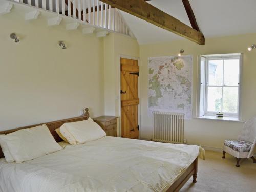 a bedroom with a bed and a staircase and a window at Rose Cottage in Rochester