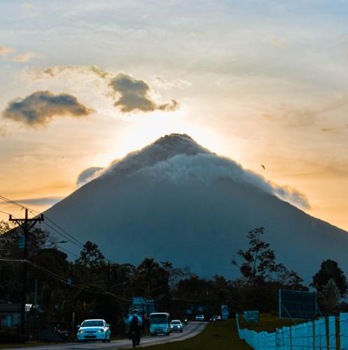 a view of a mountain with the sun setting behind it at Arenal Descanso in Fortuna