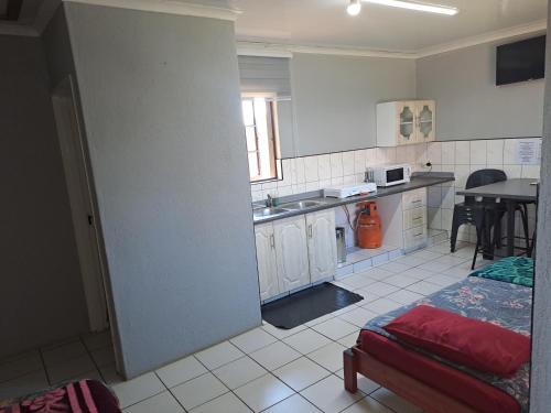 a room with a kitchen with a bed and a table at Horizon View Chalets in Graskop