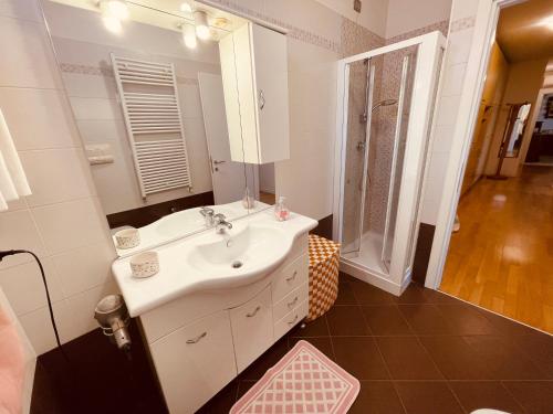a bathroom with a sink and a mirror and a shower at App4rent Family Apartment 3 camere, 2 bagni, Wi-Fi, animali ammessi in Jesolo