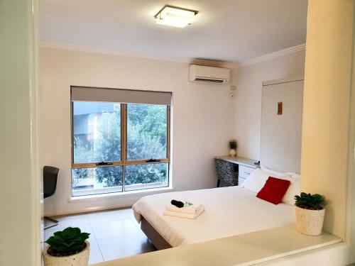 1 dormitorio con 2 camas y ventana grande en M4 West Perth Studio Apartment near Kings Park en Perth