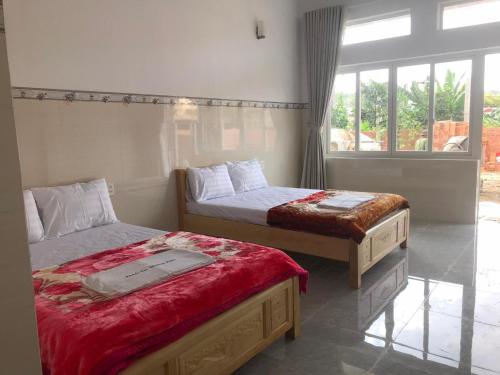 a bedroom with two beds and a window at Phuong Ngan Guesthouse in Bao Loc