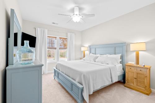 biała sypialnia z niebieskim łóżkiem i oknem w obiekcie Presleys Place w mieście Beaufort