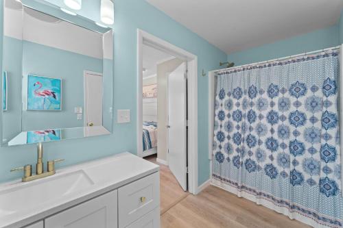 a bathroom with a sink and a shower curtain at The Sandy Eagle in Kill Devil Hills
