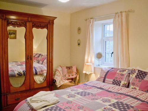 1 dormitorio con 1 cama, vestidor y ventana en Court House en Hay-on-Wye