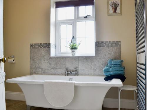 a white bath tub in a bathroom with a window at Court House in Hay-on-Wye