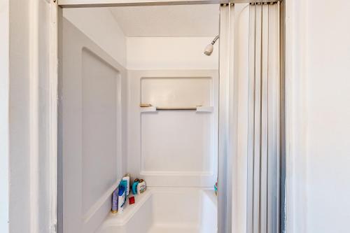 a bathroom with a white shower curtain next to a door at Mountain Vista - Barn in Hesperus