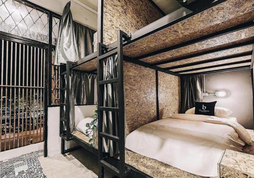 a bedroom with two bunk beds and a brick wall at BLOOMZ HOSTEL in Chiang Mai