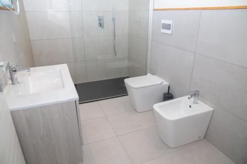 a white bathroom with a sink and a toilet at Delfino Tuscany Resort in Marina di Cecina