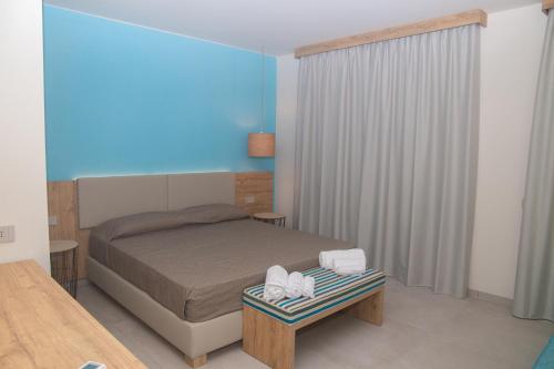 a bedroom with a bed and a table with towels at Delfino Tuscany Resort in Marina di Cecina