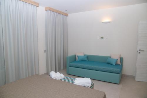 un soggiorno con un divano blu in una stanza di Delfino Tuscany Resort a Marina di Cecina