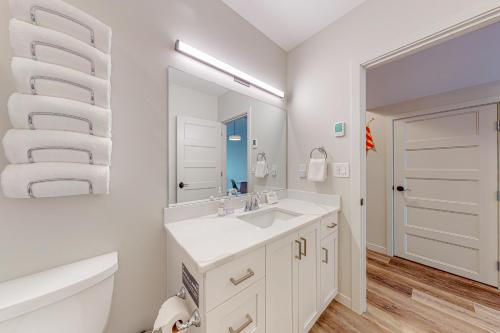 uma casa de banho branca com um lavatório e um espelho em Penn Cove Strand #E em Coupeville