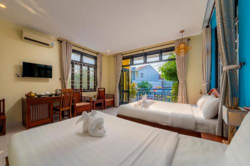 1 dormitorio con 2 camas y sala de estar en Hoi An Heart hostel Villa, en Hoi An