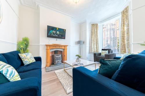 sala de estar con 2 sofás azules y chimenea en Stylish Luxury Large 4BR KingBed, en Barrow-in-Furness