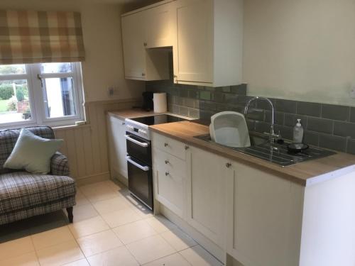 a kitchen with a sink and a stove top oven at Cute Cottage 2024 Traveller Award in Yateley