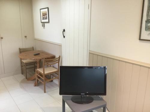 a television sitting on a table in a room at Cute Cottage 2024 Traveller Award in Yateley