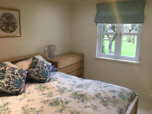 um quarto com uma cama e uma janela em Cute Cottage 2024 Traveller Award em Yateley