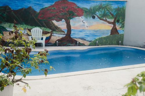 a swimming pool with a painting on the wall at Le Quindio in Bras-Panon