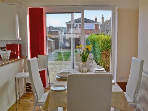 a dining room with a table and chairs and a window at Frankcot in Llandudno