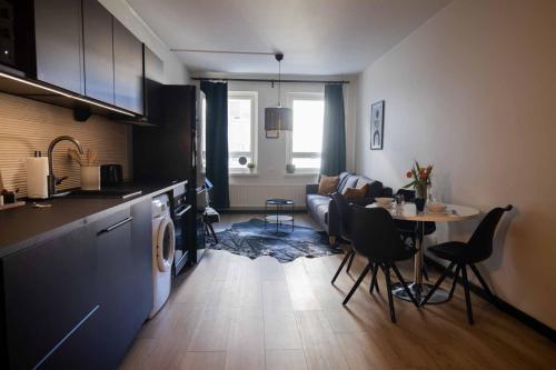 een keuken en een woonkamer met een tafel en een bank bij Studio King'sRoad in Kuopio