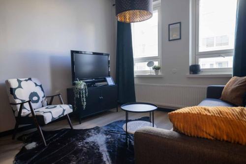 een woonkamer met een bank en een tv bij Studio King'sRoad in Kuopio