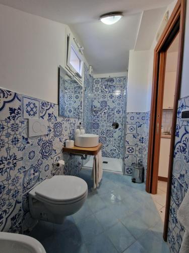 a blue and white bathroom with a toilet and a sink at B&B il vetraio in Ravello
