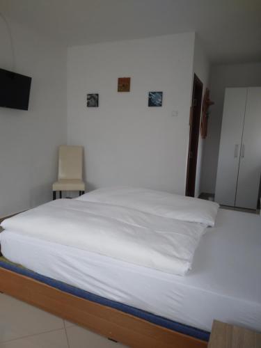 a large white bed in a room with a tv at Pensiunea Casa Ghica in Valea Sălciilor