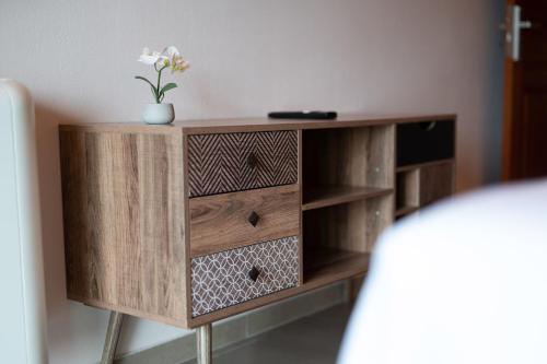 a wooden cabinet with a vase with a flower on it at Sofita με θέα τη θάλασσα Villa Athina in Preveza