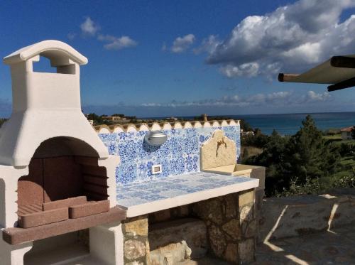 a blue and white building with a stone oven at Scopello Guidaloca Villas in Scopello