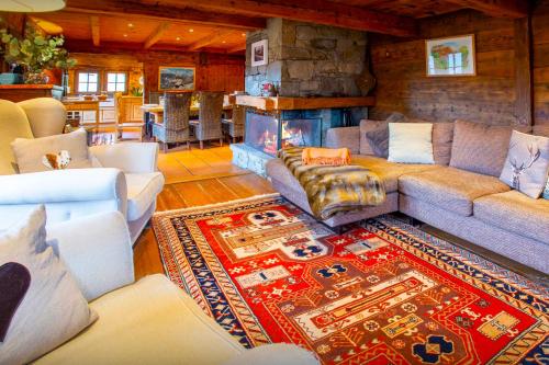 a living room with a couch and a fireplace at Chalet OVO La Vieille Ferme - OVO Network in Manigod