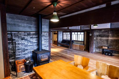 a room with a table and a wood stove at 古民家オーベルジュmocca in Kokuryō