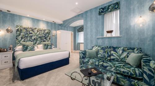 a bedroom with a bed and a couch at Applegarth Villa Hotel & Restaurant (Adult Only) in Windermere